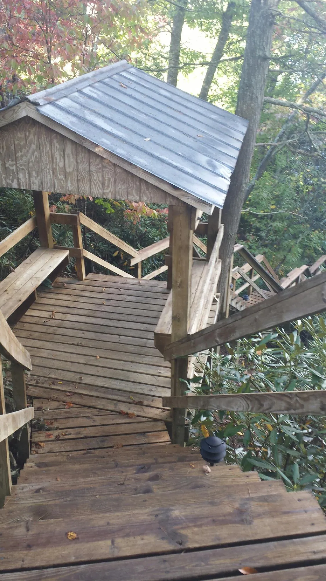 Metal roofed shelter over wooden steps on a wooded walkway — Skylight Repair & Installation work by our crew in Dent