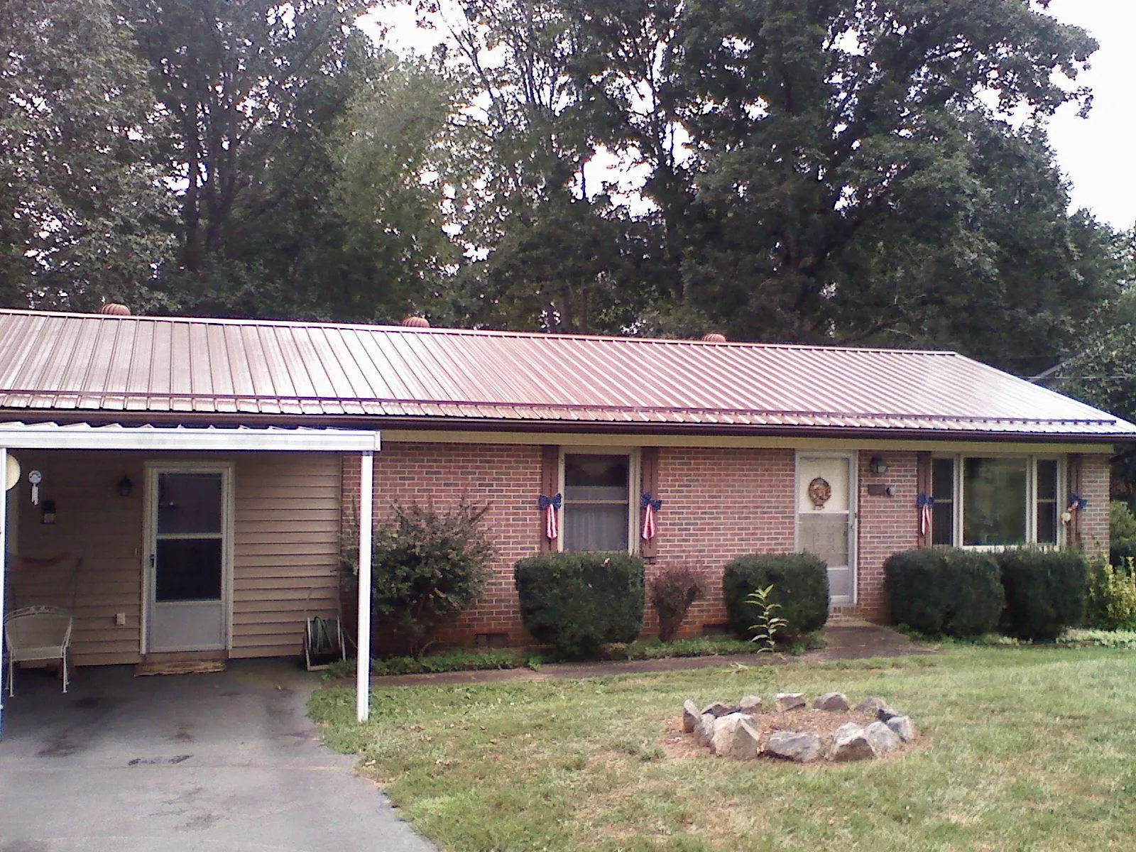 Bronze metal roof and carport on a brick ranch home — Roof Repair work by our crew in Dent